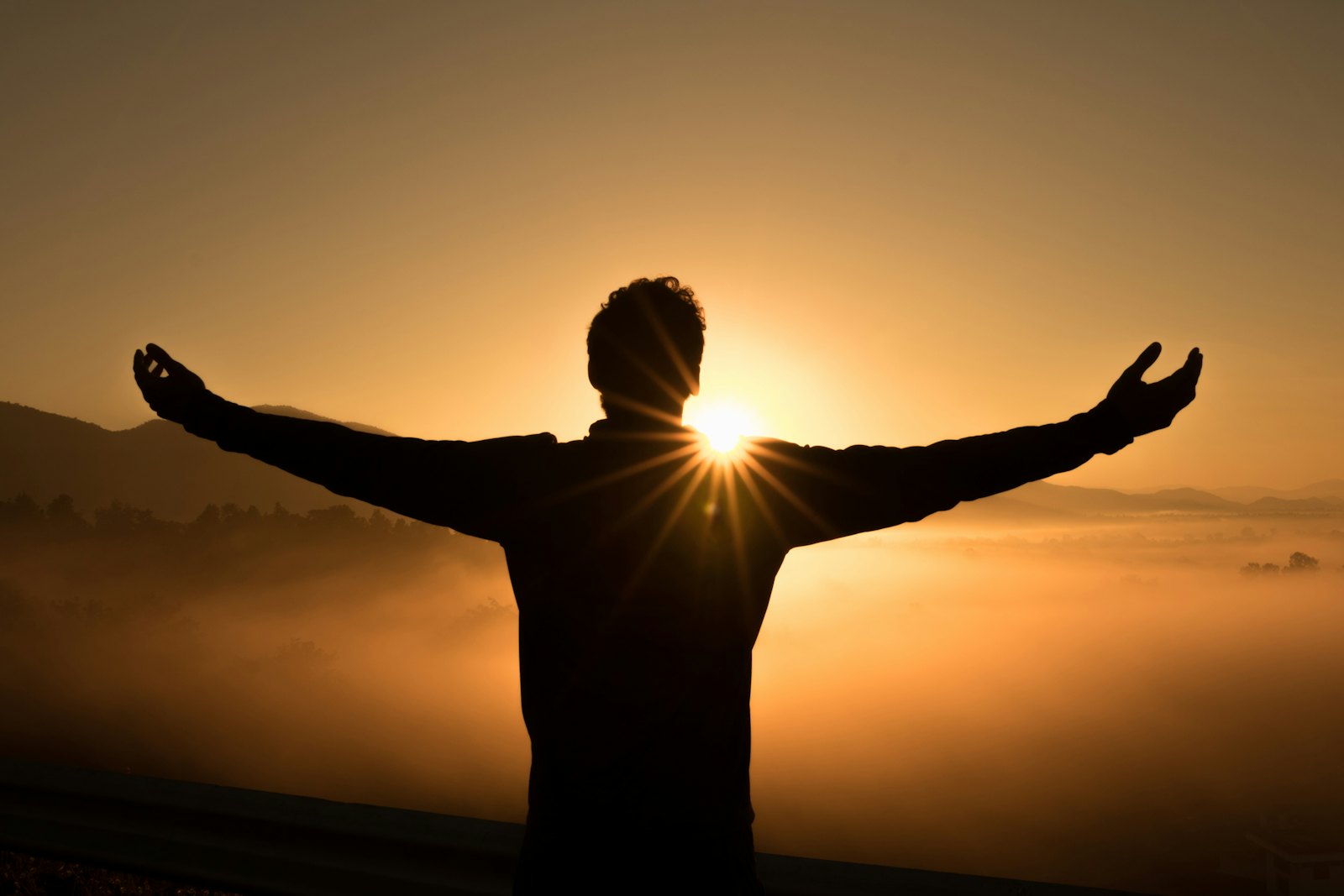 Person standing confidently on a mountaintop at sunrise, symbolizing the breakthrough moments in therapy and personal growth
